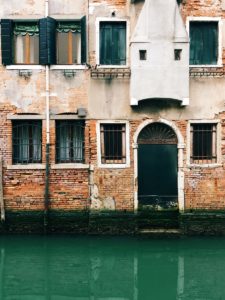 brown brick building beside river during daytime